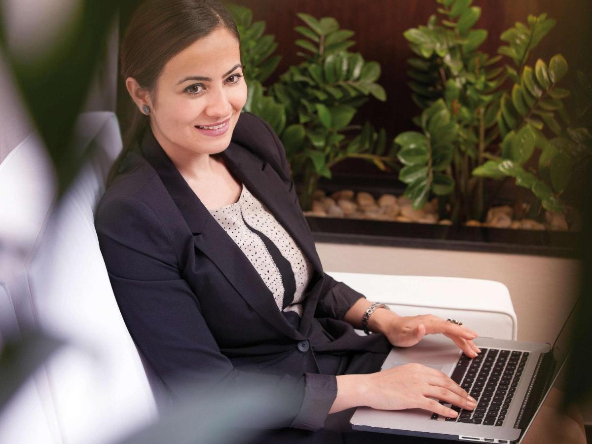 Movenpick Jumeirah Village Triangle دبي المظهر الخارجي الصورة A business woman working on a laptop